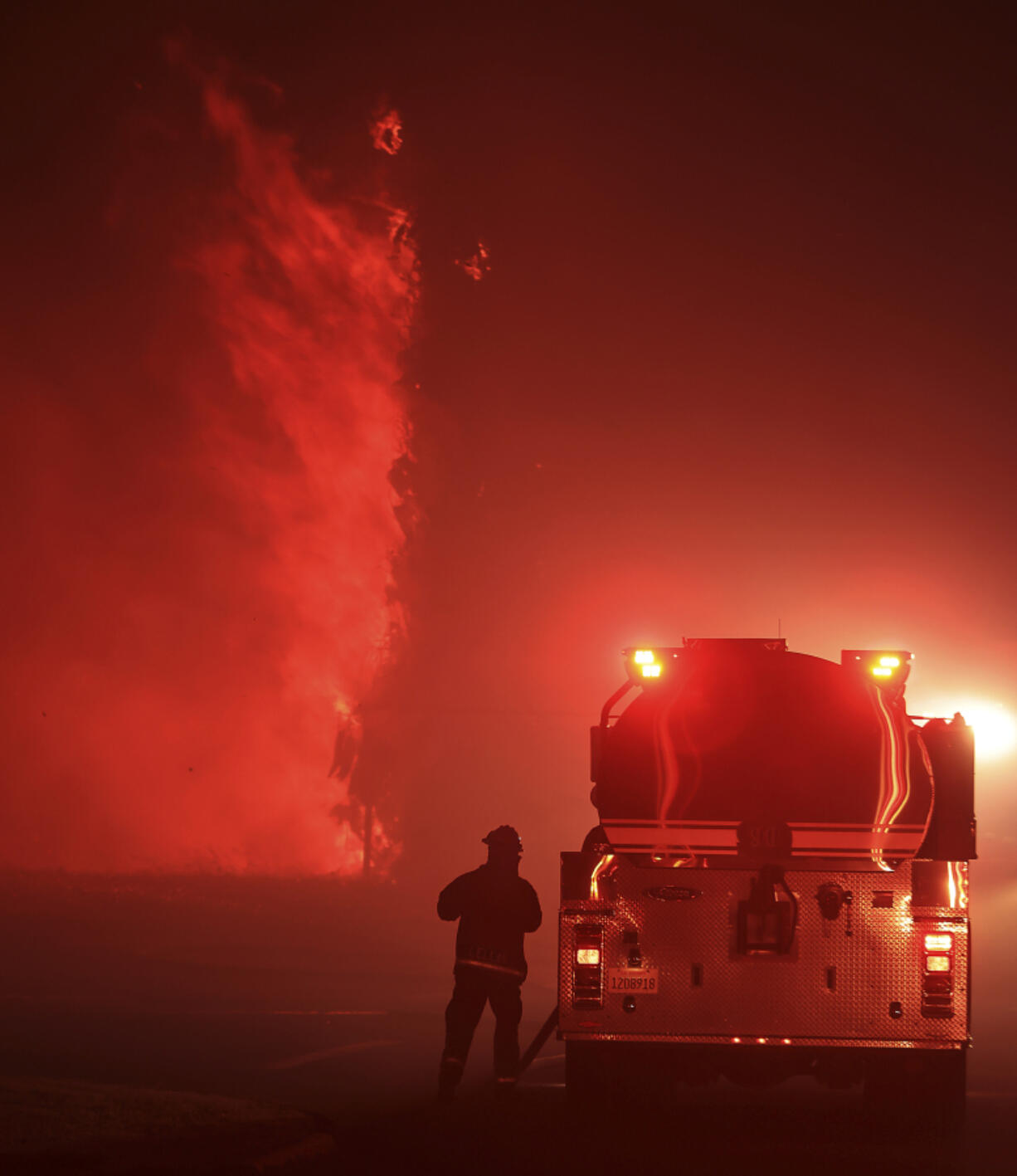 A firefighter works on Stearman and Bernard, west of Tracy, Calif. during the Corral Fire, Saturday, June 1, 2024. California firefighters aided by aircraft are battling a wind-driven wildfire in an area straddling the San Francisco Bay Area and central California.