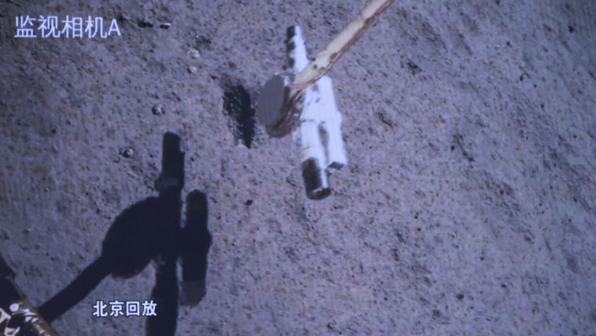 In this photo released by Xinhua News Agency, a replay screen shows Chang&rsquo;e-6 probe collecting samples on the moon surface, at Beijing Aerospace Control Center (BACC) in Beijing, Tuesday, June 4, 2024. China says a spacecraft carrying rock and soil samples from the far side of the moon has lifted off from the lunar surface to start its journey back to Earth.