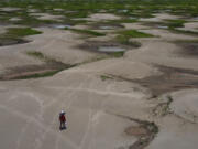 FILE - A resident of a riverside community carries food and containers of drinking water after being distributed due to the ongoing drought in Careiro da Varzea, Amazonas state, Brazil, Oct. 24, 2023.  The National Oceanic Atmospheric Administration Thursday, June 13, 2024, pronounced dead the El Nino that warms parts of the central Pacific.