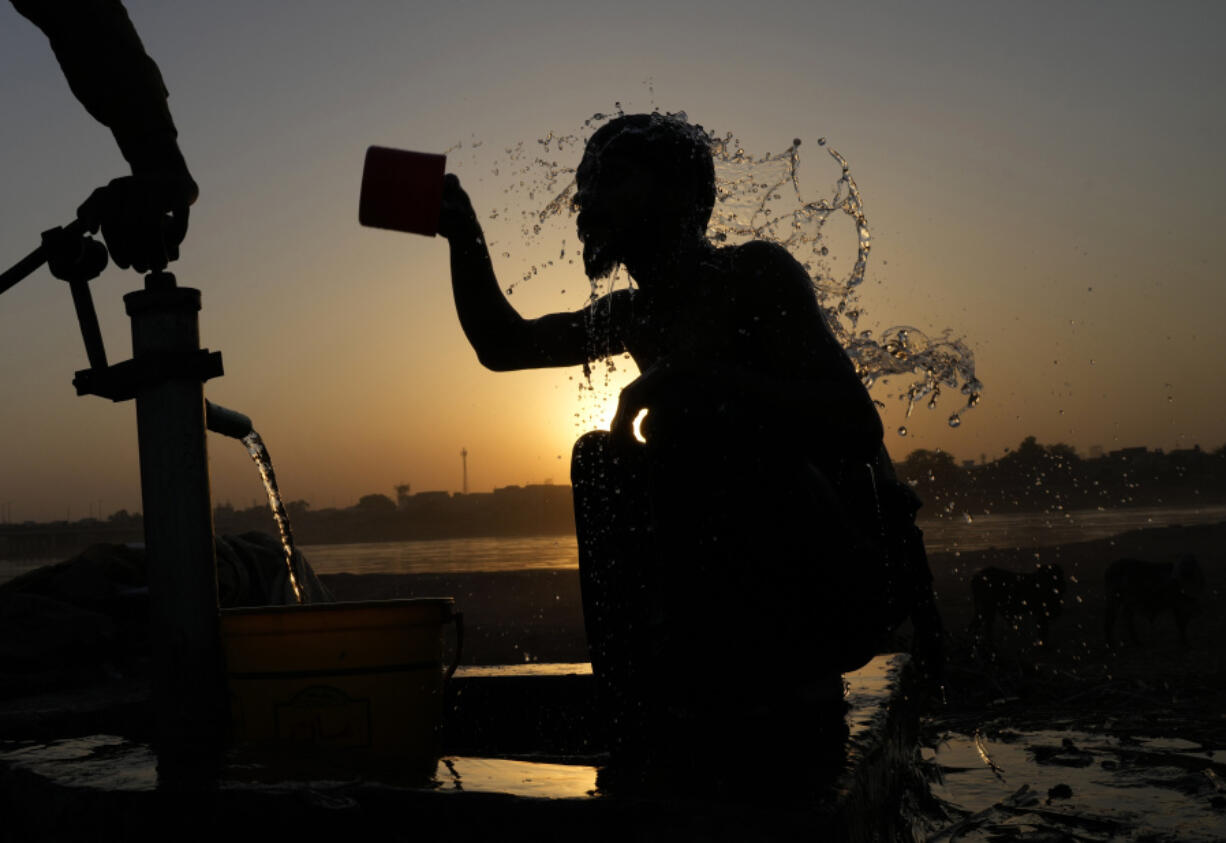 FILE - A Pakistani youth cools off under a hand pump at the sunset during hot weather in Lahore, Pakistan, May 28, 2024. Month after month, global temperatures are setting new records. (AP Photo/K.M.