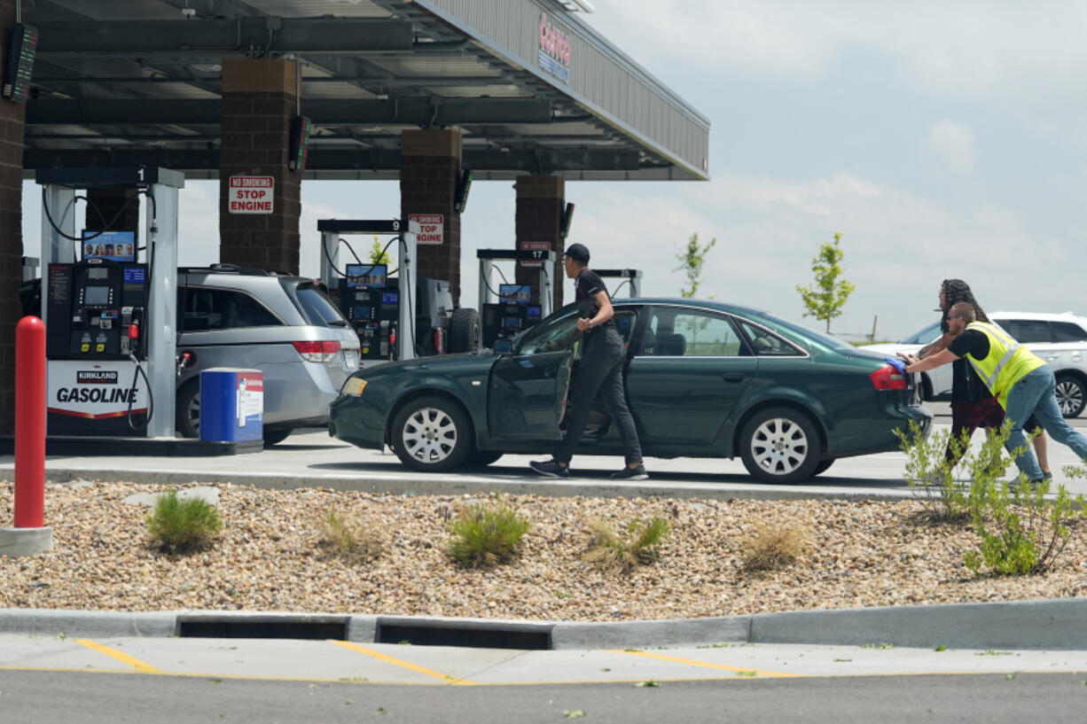 A motorist gets help reaching the gasoline pumps at a Costco warehouse May 31 in Aurora, Colo.