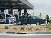 A motorist gets help reaching the gasoline pumps at a Costco warehouse May 31 in Aurora, Colo.