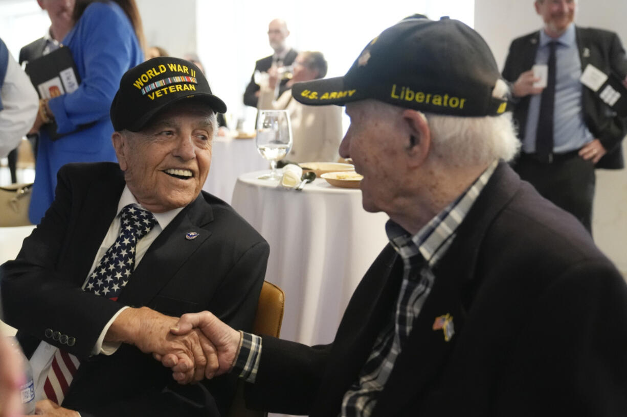 World War II veterans Andy Negra, left, and Hilbert Margol, speak to each other during an an event honoring the two on Thursday, March 14, 2024, in Atlanta.  Margol is a 100-year-old World War II veteran living in Dunwoody, Ga. He and his twin brother, Howard Margol, were a part of the 42nd Infantry that arrived in Marseille, France, in January 1945.