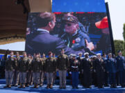 French President Emmanuel Macron is shown handing out a Legion of Honor medal on a screen during a ceremony to mark the 80th anniversary of D-Day, Thursday, June 6, 2024, in Normandy.