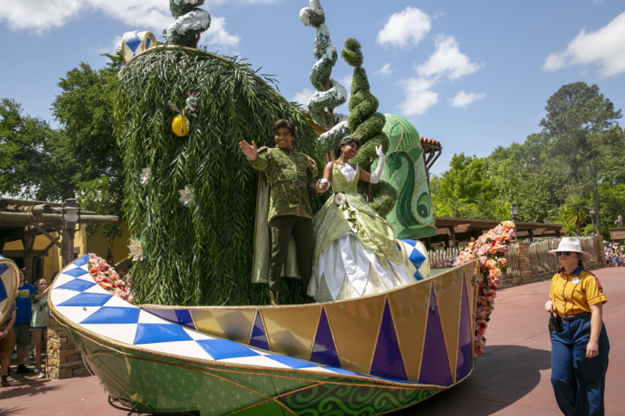 Actors dressed as Princess Tiana and Prince Naveen from The Princess and the Frog perform on a float during the Festival of Fantasy Parade at Magic Kingdom Park at Walt Disney World Resort in Lake Buena Vista, Florida, on April 18, 2022. A new attraction starring the first African American princess in Disney&rsquo;s kingdom is opening at the company&rsquo;s theme parks in Florida and California. Some Disney followers see it as fitting that the attraction starring Tiana from the 2009 film &ldquo;The Princess and the Frog&rdquo; is opening in space formerly occupied by the Splash Mountain ride.