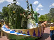 Actors dressed as Princess Tiana and Prince Naveen from The Princess and the Frog perform on a float during the Festival of Fantasy Parade at Magic Kingdom Park at Walt Disney World Resort in Lake Buena Vista, Florida, on April 18, 2022. A new attraction starring the first African American princess in Disney&rsquo;s kingdom is opening at the company&rsquo;s theme parks in Florida and California. Some Disney followers see it as fitting that the attraction starring Tiana from the 2009 film &ldquo;The Princess and the Frog&rdquo; is opening in space formerly occupied by the Splash Mountain ride.