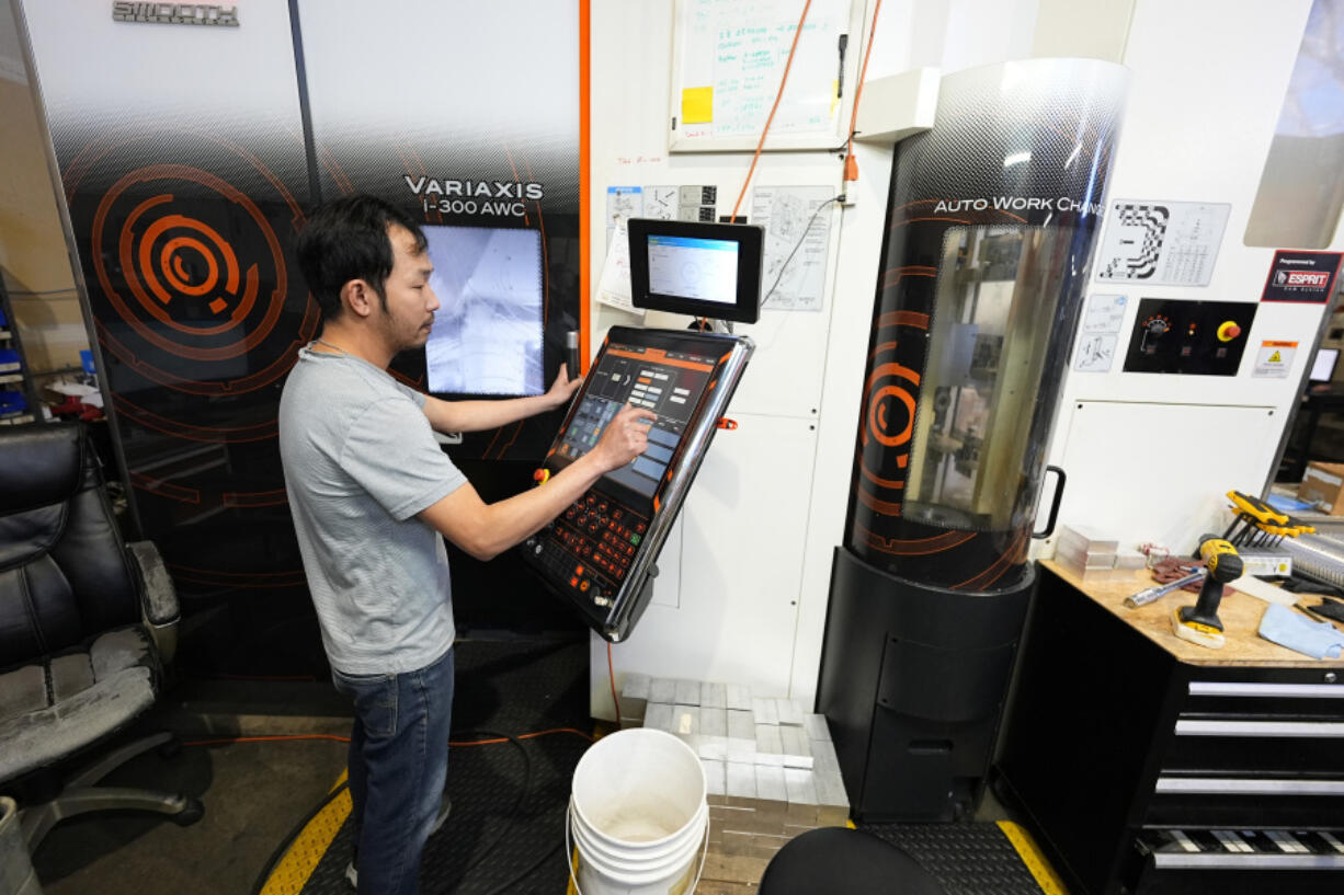 FILE - A worker at Reata Engineering and Machine Works programs a Mazak Variaxis machine used to make semiconductor pieces on Feb. 15, 2024, in Englewood, Colo. On Friday, June 7, 2024, the U.S. government issues its May jobs report.