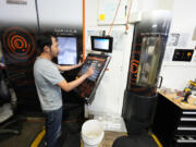 FILE - A worker at Reata Engineering and Machine Works programs a Mazak Variaxis machine used to make semiconductor pieces on Feb. 15, 2024, in Englewood, Colo. On Friday, June 7, 2024, the U.S. government issues its May jobs report.