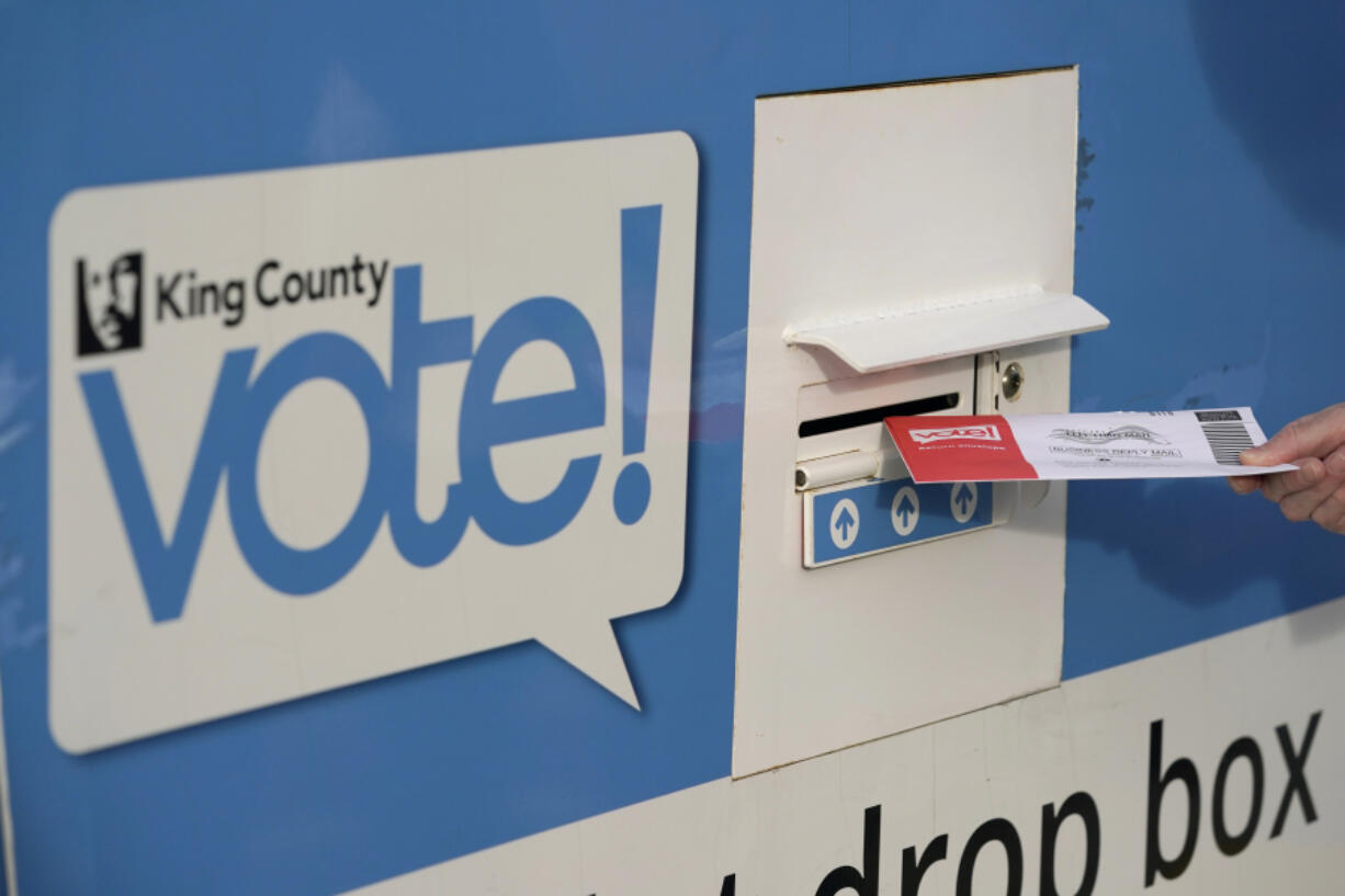 FILE - A person puts their ballot in a drop box on Oct. 27, 2020, at a library in Seattle. A Washington state judge on Friday, June 7, 2024, turned back an attempt by GOP backers of three initiatives to keep the fiscal impact of the measures off the November ballot. (AP Photo/Ted S.