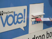 FILE - A person puts their ballot in a drop box on Oct. 27, 2020, at a library in Seattle. A Washington state judge on Friday, June 7, 2024, turned back an attempt by GOP backers of three initiatives to keep the fiscal impact of the measures off the November ballot. (AP Photo/Ted S.