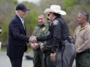 FILE - President Joe Biden talks with the U.S. Border Patrol and local officials, as he looks over the southern border, Feb. 29, 2024, in Brownsville, Texas, along the Rio Grande. Over the course of two weeks, President Joe Biden has imposed significant restrictions on immigrants seeking asylum in the U.S. and then offered potential citizenship to hundreds of thousands of people without legal status already living in the country. The two actions in tandem gives the president a chance to address one of the biggest vulnerabilities for his reelection campaign.