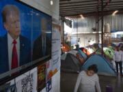Migrants waiting to apply for asylum watch the presidential debate in a shelter for migrants, Thursday, June 27, 2024, in Tijuana, Mexico.