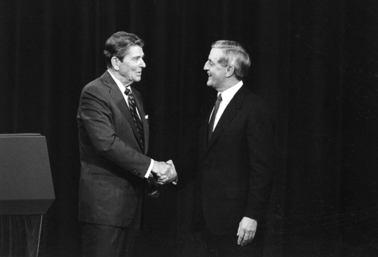 FILE - President Ronald Reagan, left, and his Democratic challenger Walter Mondale, shake hands before debating in Kansas City, Mo., Oct. 22, 1984.