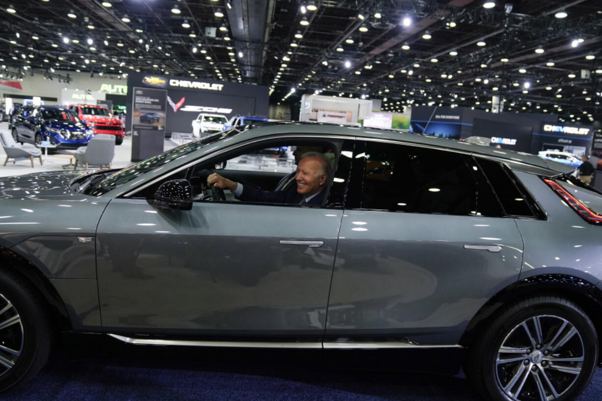 FILE - President Joe Biden drives a Cadillac Lyriq through the show room during a tour at the Detroit Auto Show Sept. 14, 2022, in Detroit. Former President Donald Trump and other Republicans portray Biden&rsquo;s policy to promote electric vehicles as unfair for consumers and government overreach. Biden and Democrats have been less vocal and more nuanced, advocating Biden&rsquo;s climate reduction goals while promoting homegrown technology over competition from China.