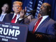 FILE - Republican presidential candidate former President Donald Trump listens as Sen. Tim Scott, R-S.C., speaks at a primary election night party at the South Carolina State Fairgrounds in Columbia, S.C., Saturday, Feb. 24, 2024. A top ally of former President Donald Trump &mdash; and a potential running mate &mdash; is launching a new effort to win over Black and other nonwhite working class voters he argues could be the deciding factor in November&rsquo;s elections. South Carolina Sen. Tim Scott, the only Black Republican in the Senate, will lead a $14 million campaign targeting minority voters in seven key swing states.