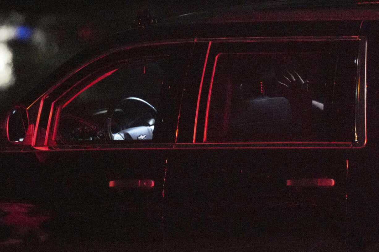 A hand waves from inside the motorcade of former President Donald Trump as he leaves Palm Beach International Airport in West Palm Beach, Fla., Sunday, June 2, 2024.