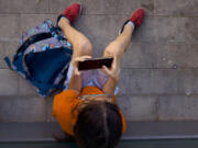 A 11-year-old boy plays with his father&rsquo;s phone outside school in Barcelona, Spain, Monday, June 17, 2024. Parents across Europe are rallying to make it normal for young kids to live smartphone-free. From Spain to Ireland and the UK, groups are ballooning on chat groups like WhatsApp and agreeing to link arms and refuse to buy children younger than 12 smartphones.