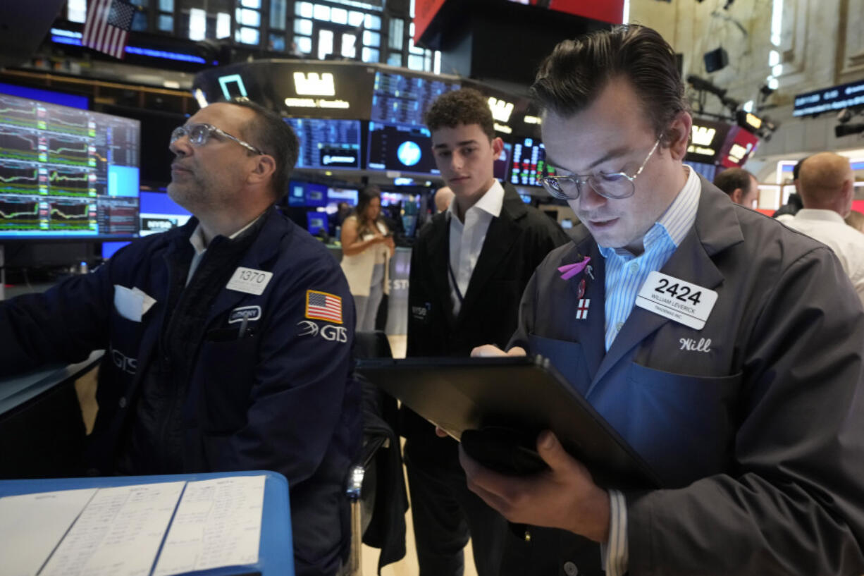 FILE - Trader William Lovesick, right works on the floor of the New York Stock Exchange, June 12, 2024. Shares have opened mixed in Europe on Monday, June 17, 2024, as markets recovered from shocks of recent elections across the region.