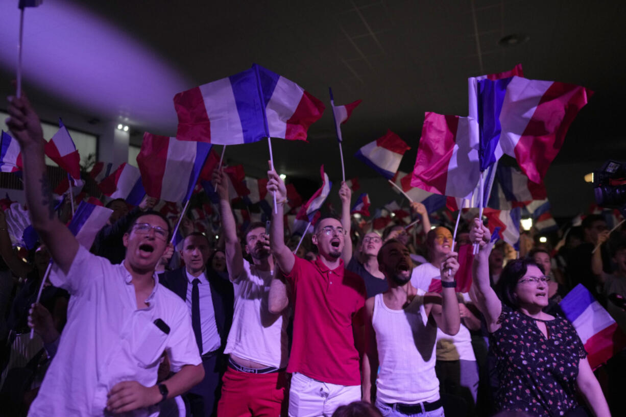 Supporters of French far right leader Marine Le Pen react after the release of projections based on the actual vote count in select constituencies , Sunday, June 30, 2024 in Henin-Beaumont, northern France. French voters propelled the far-right National Rally to a strong lead in first-round legislative elections Sunday and plunged the country into political uncertainty, according to polling projections.