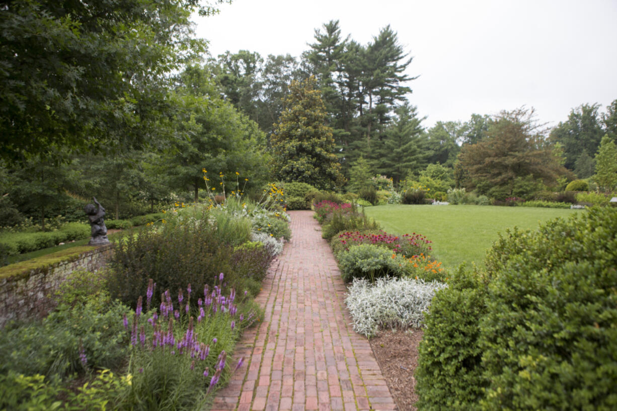 This undated photo provided by Mt. Cuba Center shows formal native plantings, including Asclepias tuberosa, Echinacea purpurea, Liatris, Physocarpus opulifolius and Artemesia ludoviciana, flanking a walkway at Mt. Cuba Center botanical garden in Hockessin, Del. (Alessandra Stokely/Mt. Cuba Center via AP) (Photos by Melissa Starkey/Mt.