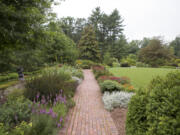 This undated photo provided by Mt. Cuba Center shows formal native plantings, including Asclepias tuberosa, Echinacea purpurea, Liatris, Physocarpus opulifolius and Artemesia ludoviciana, flanking a walkway at Mt. Cuba Center botanical garden in Hockessin, Del. (Alessandra Stokely/Mt. Cuba Center via AP) (Photos by Melissa Starkey/Mt.