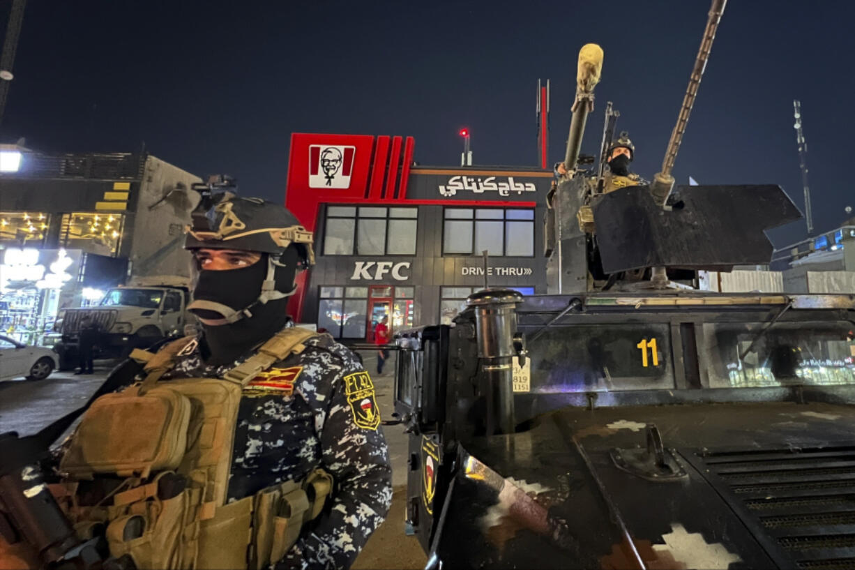 Iraqi security forces stand guard in front of Kentucky Fried Chicken restaurant in Baghdad, Wednesday, June 5, 2024. The recent protests &mdash; apparently organised by supporters of Iran-backed, anti-American militias in Iraq &mdash; reflect surging anger against the United States, Israel&rsquo;s top ally, over the war in Gaza.