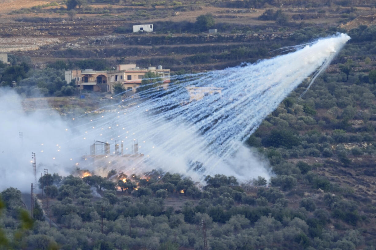 FILE - A shell that appears to be white phosphorus from Israeli artillery explodes over a house in al-Bustan, a Lebanese village along the border with Israel, on Oct. 15, 2023. A global human rights group claimed in a report published Wednesday, June 5, 204, that Israel has used white phosphorus incendiary shells on residential buildings in at least five towns and villages in conflict-hit southern Lebanon, possibly harming civilians and violating international law.