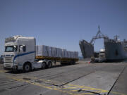 U.S. Army soldiers stand next to trucks arriving loaded with humanitarian aid at the U.S.-built floating pier Trident before reaching the beach on the coast of the Gaza Strip, Tuesday, June 25, 2024.