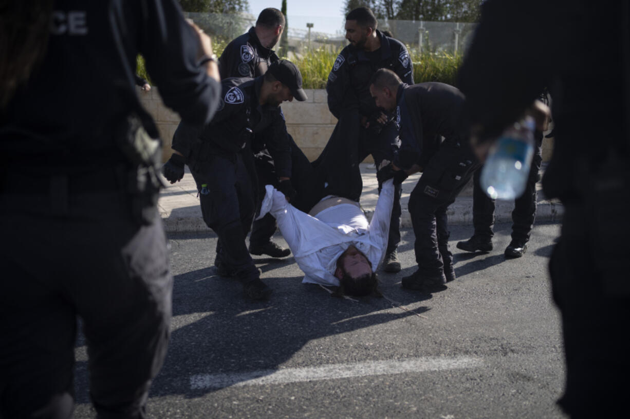 FILE - Israeli police officers remove an ultra-Orthodox Jewish man from the street during a protest against army recruitment in Jerusalem on June 2, 2024. Israel&rsquo;s Supreme Court on Tuesday, June 25, ruled unanimously that the military must begin drafting ultra-Orthodox men for military service, a decision that could lead to the collapse of Prime Minister Benjamin Netanyahu&rsquo;s governing coalition as Israel continues to wage war in Gaza.