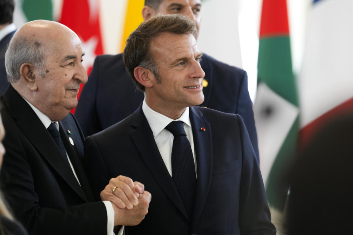 French President Emmanuel Macron, right shakes hands with Algerian President Abdelmadjid Tebboune during a working session on AI, Energy, Africa and Mideast at the G7 summit, in Borgo Egnazia, near Bari in southern Italy, Friday, June 14, 2024.