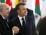 French President Emmanuel Macron, right shakes hands with Algerian President Abdelmadjid Tebboune during a working session on AI, Energy, Africa and Mideast at the G7 summit, in Borgo Egnazia, near Bari in southern Italy, Friday, June 14, 2024.