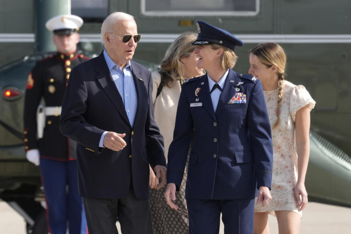 President Joe Biden is escorted by Air Force Col. Angela Ochoa, Commander, 89th Airlift Wing, as he arrives at Andrews Air Force Base, Md., Wednesday, June 12, 2024. Biden is headed to Italy for the G7 summit. Biden&rsquo;s granddaughter, Finnegan Biden, walks right.