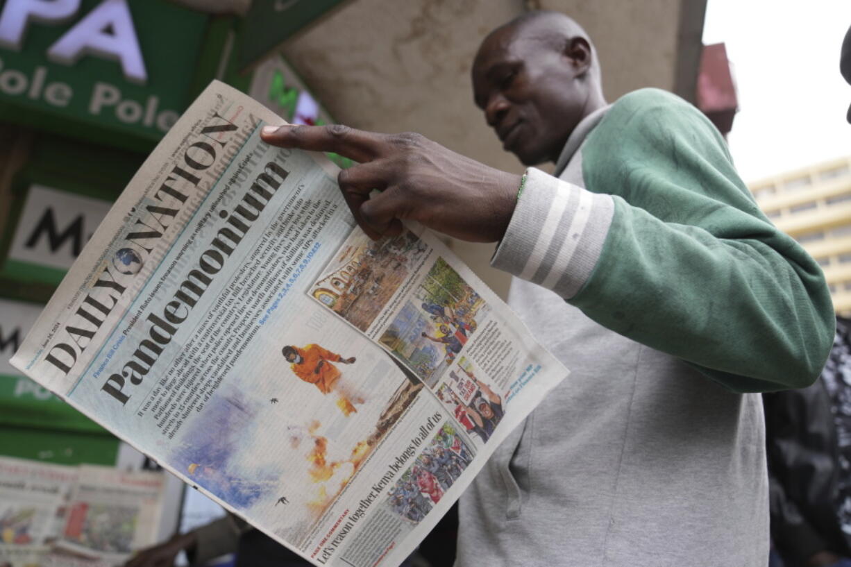 A man reads about yesterday&rsquo;s protest in a newspaper in downtown Nairobi, Kenya Wednesday, June 26, 2024. Thousands of protesters stormed and burned a section of Kenya&rsquo;s parliament Tuesday to protest tax proposals. Police responded with gunfire and several protesters were killed.