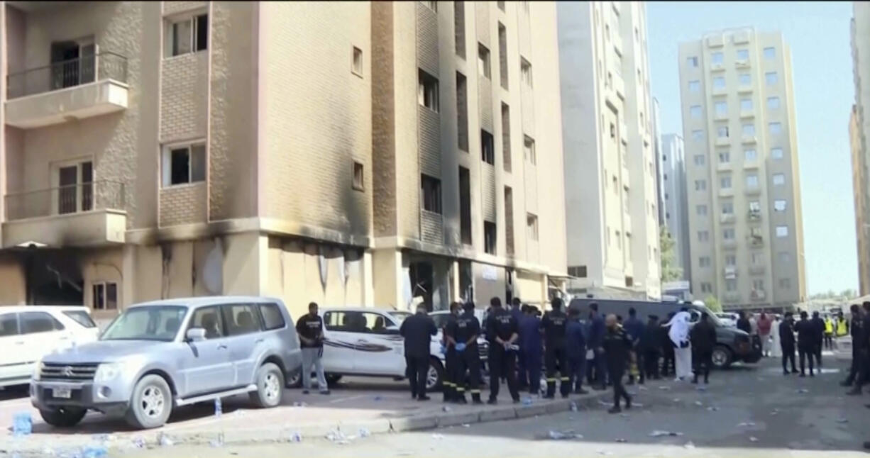 Rescuers arrive at the site of a building that caught fire in Kuwait, Wednesday, June 12, 2024. At least 41 people died when a fire swept through a building that housed workers in Kuwait early Wednesday, and officials said the blaze appeared to be linked to code violations.