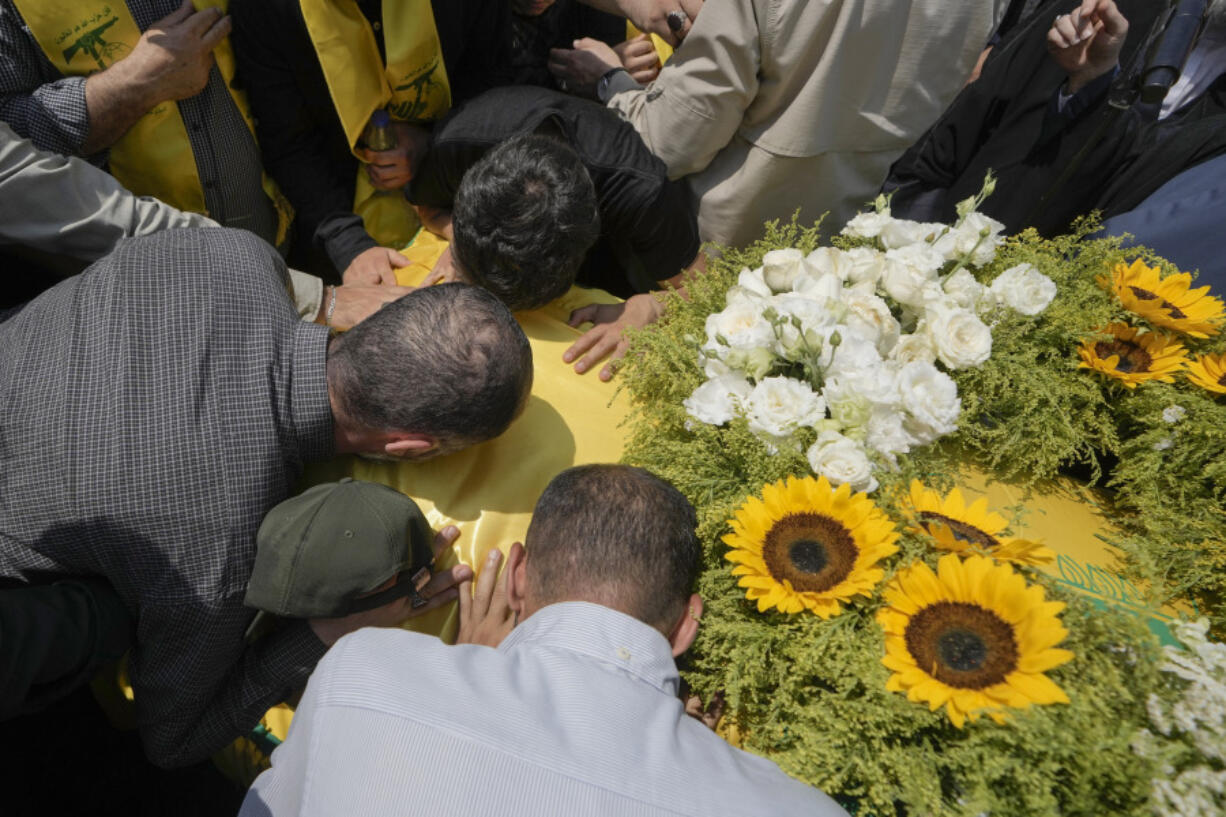 Mourners kiss the coffin of Hezbollah senior commander Taleb Sami Abdullah, 55, known within Hezbollah as Hajj Abu Taleb, who was killed late Tuesday by an Israeli strike in south Lebanon, during his funeral procession in the southern suburbs of Beirut, Lebanon, Wednesday, June 12, 2024. Hezbollah fired a massive barrage of rockets into northern Israel on Wednesday to avenge the killing of the top commander in the Lebanese militant group as the fate of an internationally-backed plan for a cease-fire in Gaza hung in the balance.