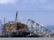 FILE - The collapsed Francis Scott Key Bridge rests on the container ship Dali, May 12, 2024, in Baltimore, as seen from Riviera Beach, Md. Crew members on the cargo ship Dali can head home as soon as Thursday, June 20, 2024, under an agreement that allows lawyers to question them amid ongoing investigations into what led to the deadly collapse of Baltimore&rsquo;s Francis Scott Key Bridge.