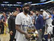 Dallas Mavericks guard Kyrie Irving holds the Western Conference Trophy after Game 5 of the Western Conference finals in the NBA basketball playoffs against the Minnesota Timberwolves, Thursday, May 30, 2024, in Minneapolis. The Mavericks won 124-103, taking the series 4-1 and moving on to the NBA Finals.