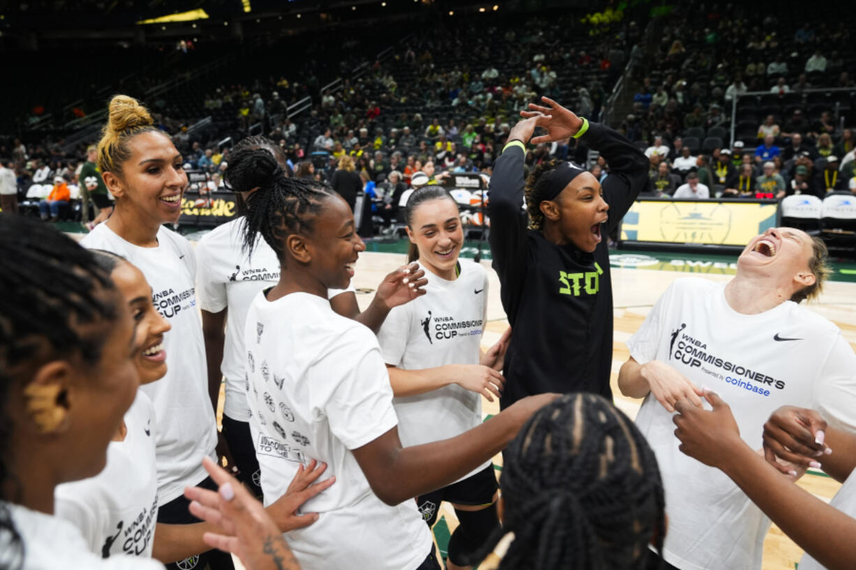 Seattle Storm players, including center Mercedes Russell, third from left, guard Jewell Loyd, guard Nika Muhl, guard Jordan Horston and guard Sami Whitcomb, right, laugh as they huddle before facing the Phoenix Mercury in a WNBA basketball game Tuesday, June 4, 2024, in Seattle.