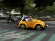 An antique Volkswagen Beetle, known in Mexico as a &ldquo;vocho,&rdquo; parades through the streets a day after World Vocho Day, in Mexico City, Sunday, June 23, 2024.