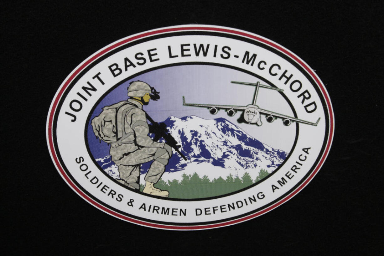 FILE - The logo of Joint Base Lewis-McChord is seen at a ceremony marking the merger of Fort Lewis and McChord Air Force Base into Joint Base Lewis-McChord, Feb. 1, 2010, in Washington state. Fifteen current or retired Joint Base Lewis-McChord servicemen who say the Army failed to protect them from a military doctor who&#039;s been charged with sexual abuse are seeking $5 million in damages for the emotional distress they say they&#039;ve suffered.  (AP Photo/Ted S.