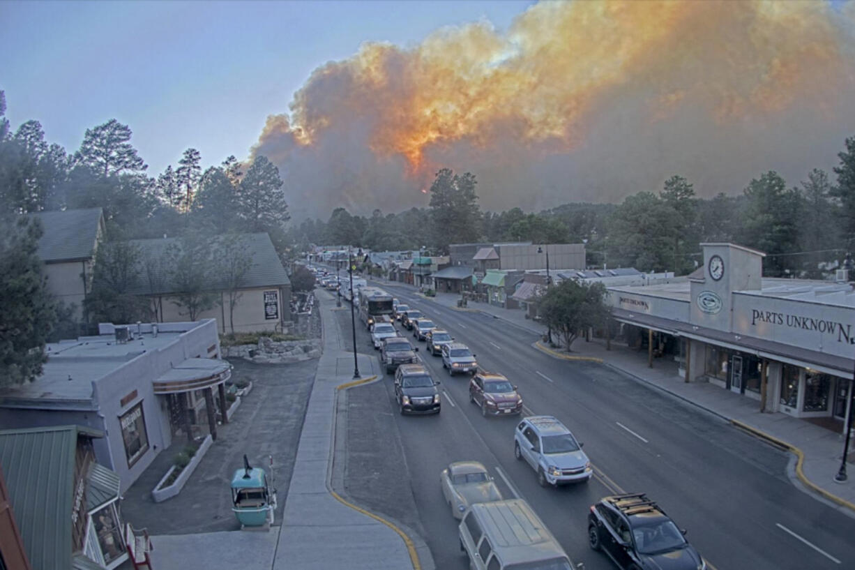 In this image taken from webcam footage provided by the Village of Ruidoso, smoke rises behind Ruidoso, N.M., on Monday, June 17, 2024. Thousands of southern New Mexico residents fled the mountainous village as a wind-whipped wildfire tore through homes and other buildings.