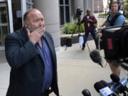 Right-wing conspiracy theorist Alex Jones wipes his mouth as he speaks to the media after arriving at the federal courthouse for a hearing in front of a bankruptcy judge Friday, June 14, 2024, in Houston. The judge is expected to rule on whether to liquidate Jones&rsquo; assets to help pay the $1.5 billion he owes for his false claims that the Sandy Hook Elementary School shooting was a hoax. (AP Photo/David J.