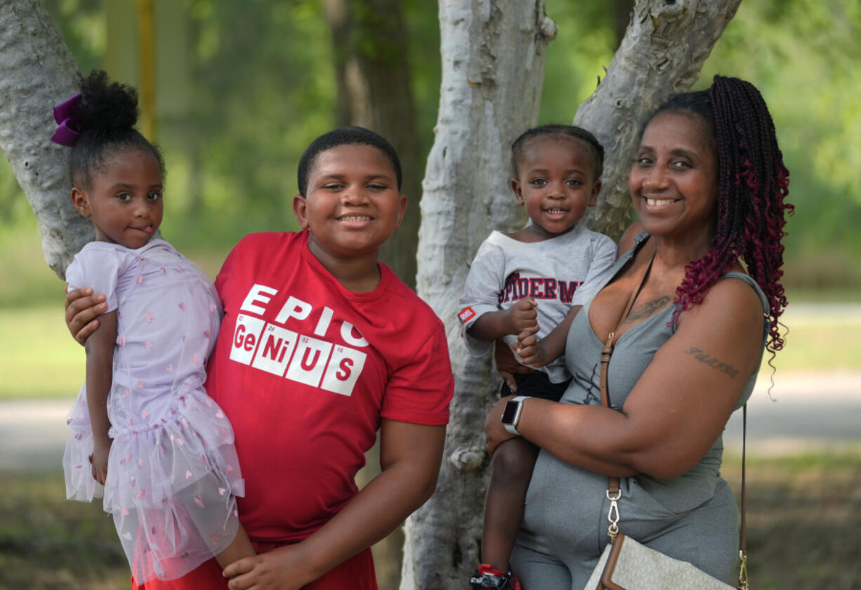 Tamika Davis, right, poses with three of her children, from left, Shanara, 3, Matthew, 11, and Lionel Jr., 2, at MLK Park in San Antonio, Thursday, May 30, 2024. Davis said friends and family watched her kids for most of her doctor visits during treatment last year for colon cancer. But she couldn&rsquo;t afford additional childcare, and she didn&rsquo;t know where to look for assistance.