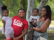 Tamika Davis, right, poses with three of her children, from left, Shanara, 3, Matthew, 11, and Lionel Jr., 2, at MLK Park in San Antonio, Thursday, May 30, 2024. Davis said friends and family watched her kids for most of her doctor visits during treatment last year for colon cancer. But she couldn&rsquo;t afford additional childcare, and she didn&rsquo;t know where to look for assistance.