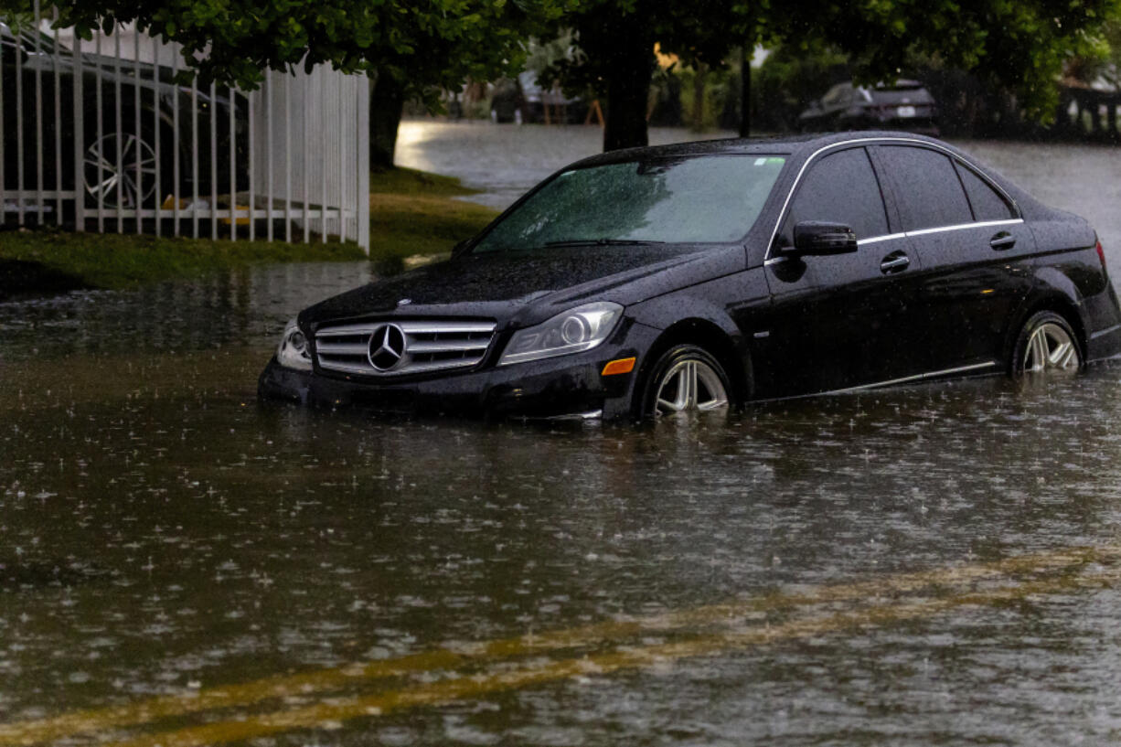 A vehicle stranded by the flooded road due to heavy rain in Sunny Isles Beach in Fla,, Wednesday, June 12, 2024. The annual rainy season has arrived with a wallop in much of Florida, where a disorganized disturbance of tropical weather from the Gulf of Mexico has caused street flooding and triggered tornado watches but so far has not caused major damage or injuries.