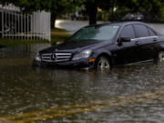 A vehicle stranded by the flooded road due to heavy rain in Sunny Isles Beach in Fla,, Wednesday, June 12, 2024. The annual rainy season has arrived with a wallop in much of Florida, where a disorganized disturbance of tropical weather from the Gulf of Mexico has caused street flooding and triggered tornado watches but so far has not caused major damage or injuries.