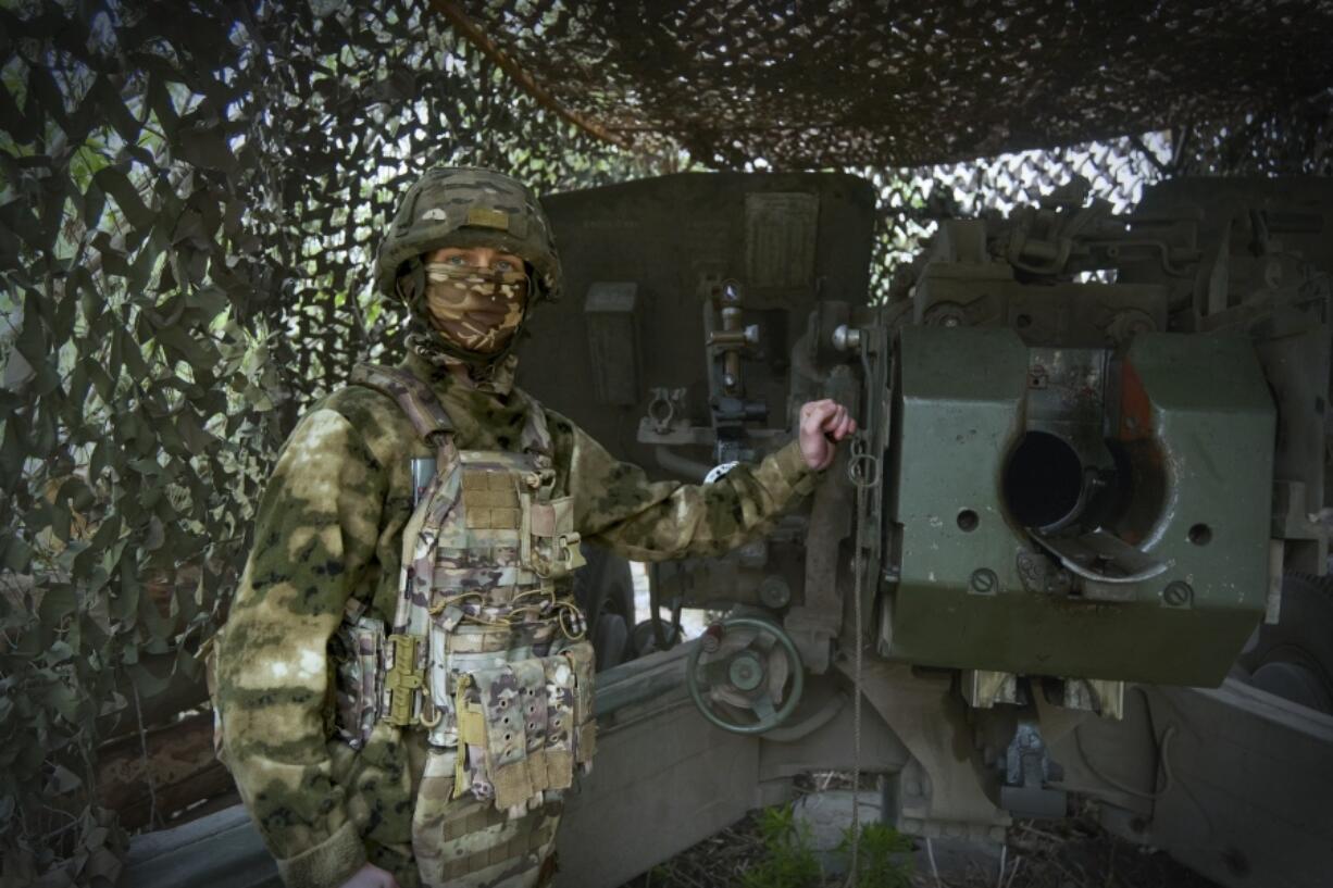 In this photo taken on Friday, April 26, 2024 and released by the Russian Defense Ministry Press Service, a Russian soldier poses for a photo next to a 2A65 &quot;Msta-B&quot; howitzer at a position in an undisclosed location in Ukraine.