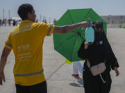 A pilgrim receives cold water spray after she cast stones at a pillar in the symbolic stoning of the devil, the last rite of the annual Hajj pilgrimage in Mina, near the holy city of Mecca, Saudi Arabia, Tuesday, June 18, 2024. Muslim pilgrims were wrapping up the Hajj pilgrimage in the deadly summer heat on Tuesday with the third day of the symbolic stoning of the devil, and the farewell circling around Kaaba in Mecca&rsquo;s Grand Mosque.