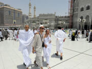 Two blind pilgrims preform Hajj with the help of their guide outside of the Grand Mosque during the annual pilgrimage in Mecca, Saudi Arabia, Thursday, June 13, 2024. Hajj is the annual Islamic pilgrimage to Mecca in Saudi Arabia that is required once in a lifetime of every Muslim who can afford it and is physically able to make it. Some Muslims make the journey more than once.