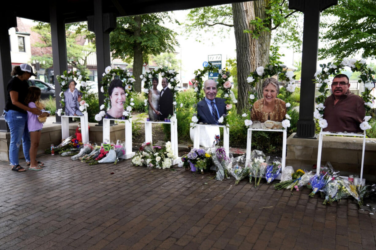 FILE - Visitors pay their respects, Thursday, July 7, 2022, at altars for the seven people killed in the Fourth of July mass shooting in Highland Park, Ill. Robert Crimo III, accused of killing seven people and injuring dozens more, including children, at a Fourth of July parade in suburban Chicago in 2022 is scheduled for a court hearing Wednesday, June 26, 2024,  when it is possible he will change his not guilty plea, the  prosecutor says.  (AP Photo/Nam Y.